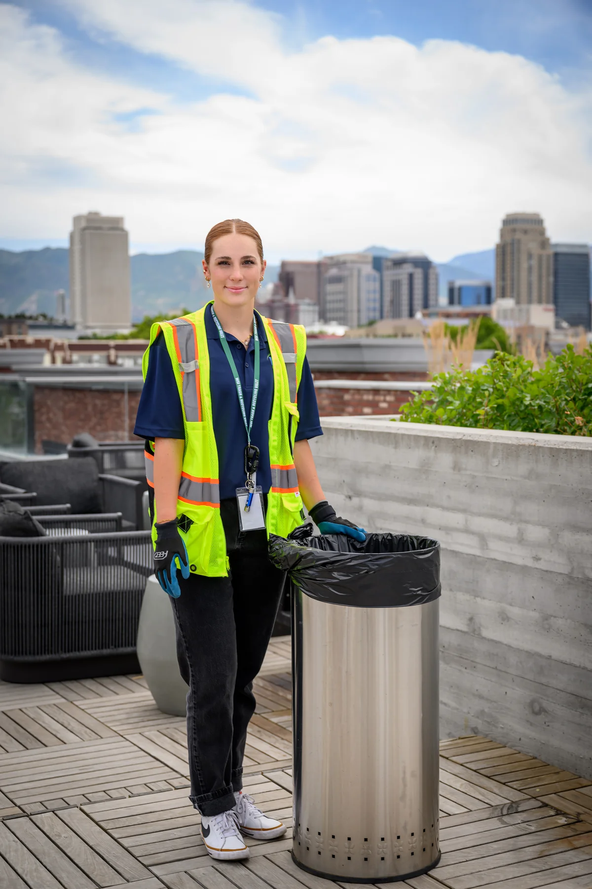 A WSI associate servicing a waste receptacle on a community rooftop terrace